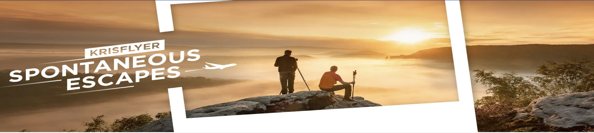 Two people sitting on a cliff and watching the sunrise