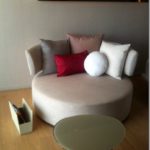 a round couch with pillows on it