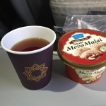 a cup of tea and a container of food