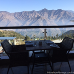 a table and chairs on a balcony overlooking mountains