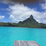 a dock over a body of water with a mountain in the background