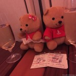 two teddy bears next to a couple of glasses of champagne