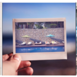 a hand holding a polaroid of a pool