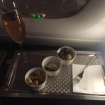 a tray with food and a glass of wine