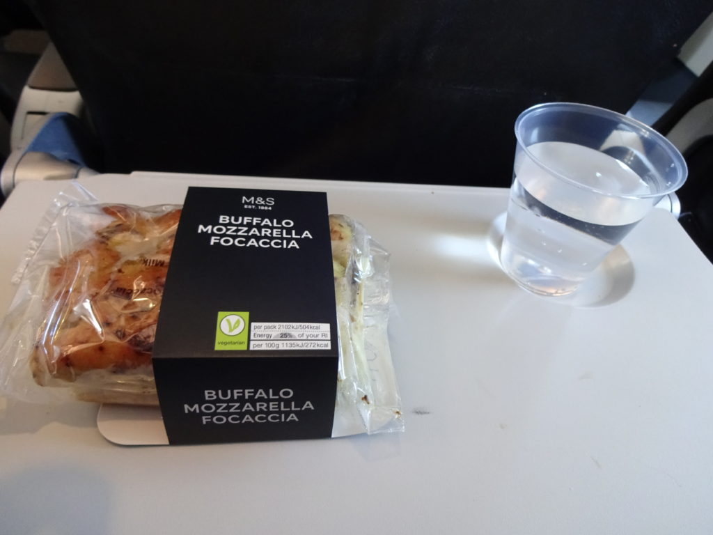 a food in a plastic bag next to a glass of water