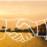 handshake over water with house and trees in the background