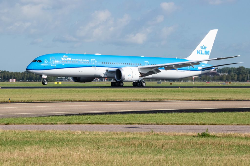 a blue and white airplane on a runway
