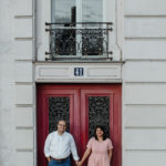 a man and woman standing in front of a building