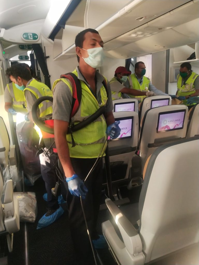 a man wearing a mask and gloves standing in a plane