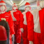 a group of people wearing red and white protective suits and masks