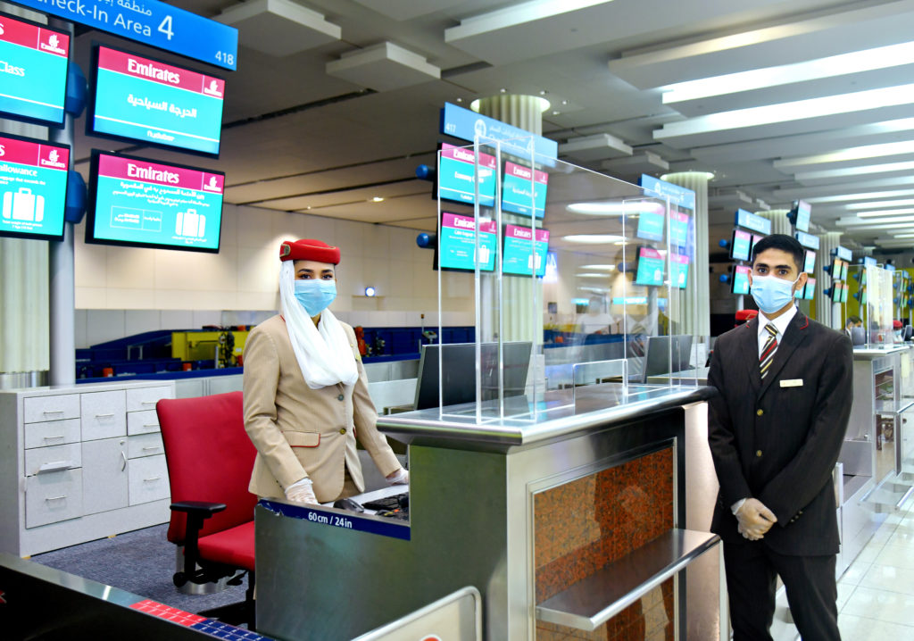 a man and woman wearing face masks standing at a counter