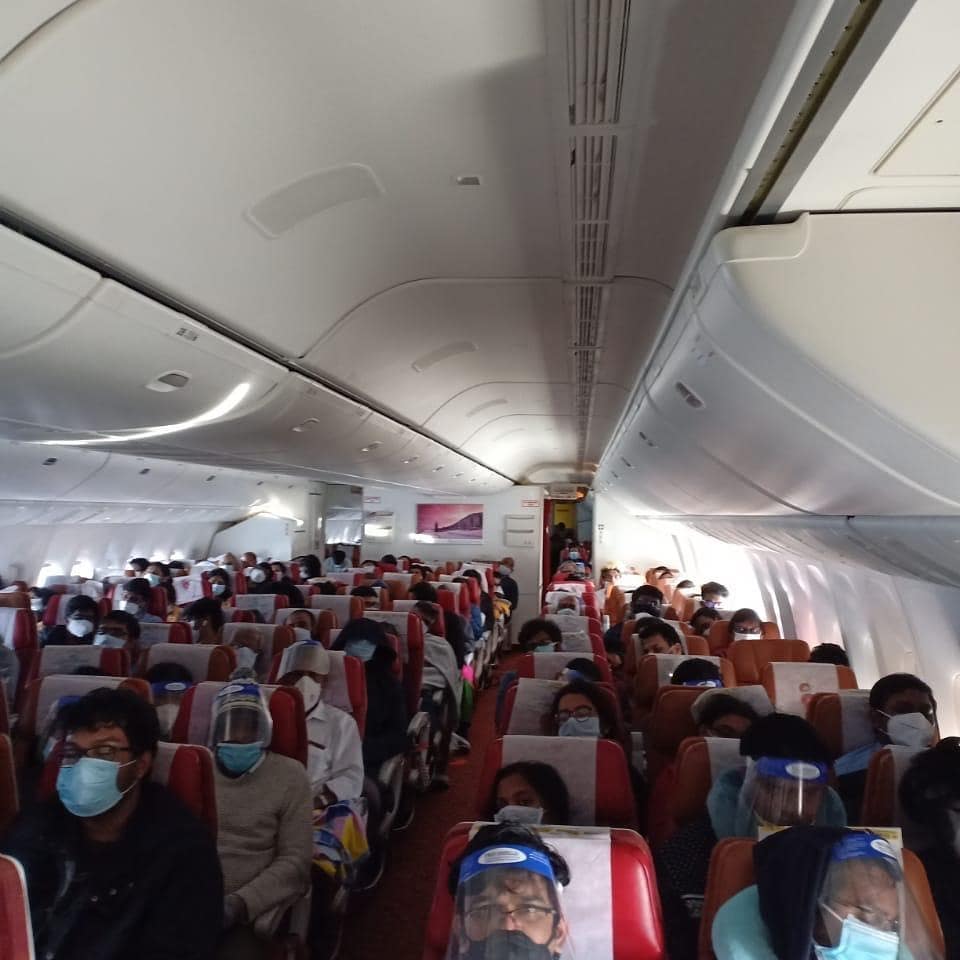 a group of people on an airplane with face masks
