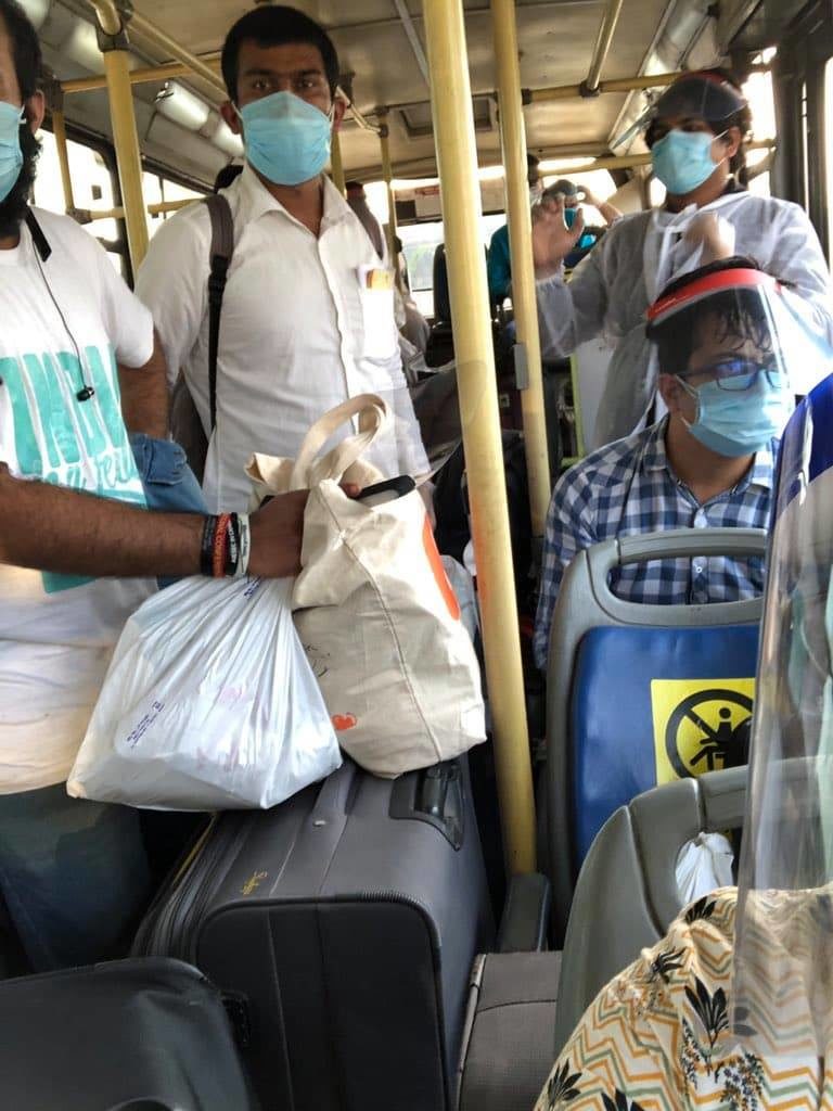 a group of people wearing face masks and standing on a bus