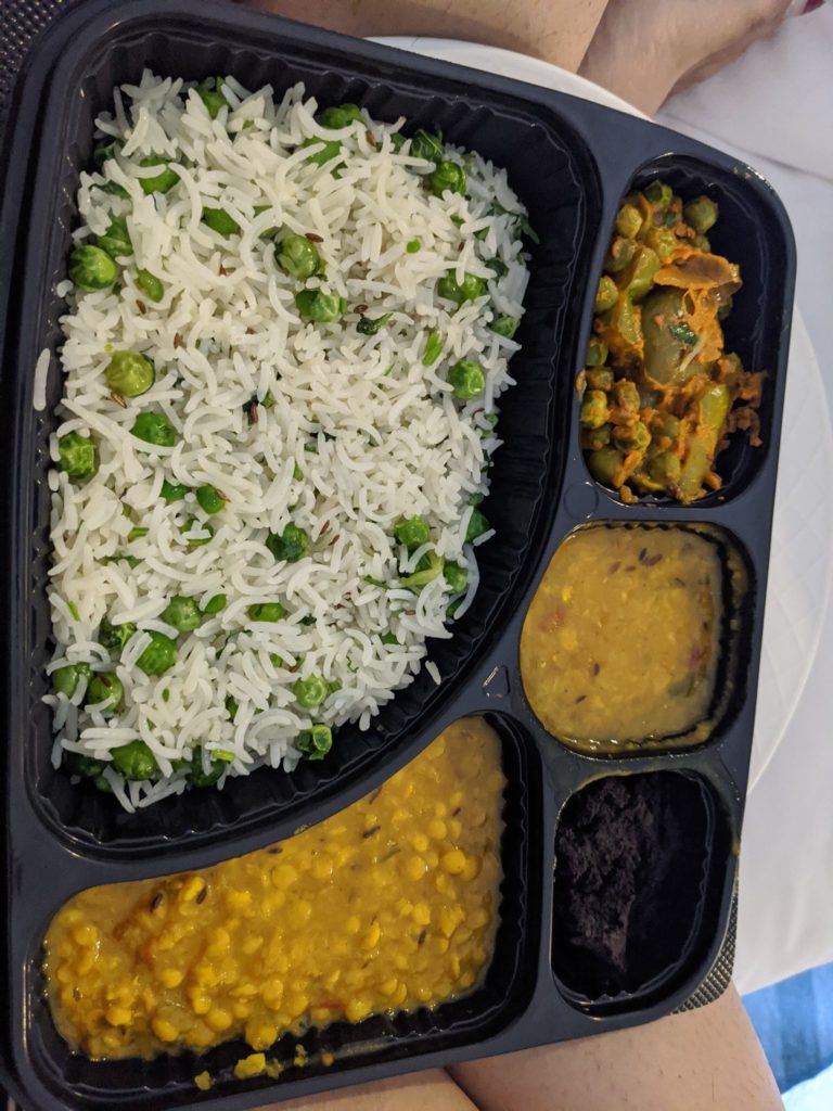 a tray of food with rice and vegetables