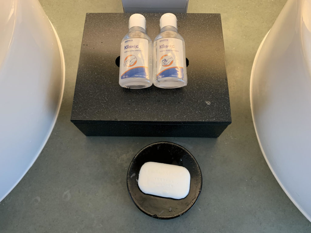 a soap dish and two bottles of hand sanitizer on a black box