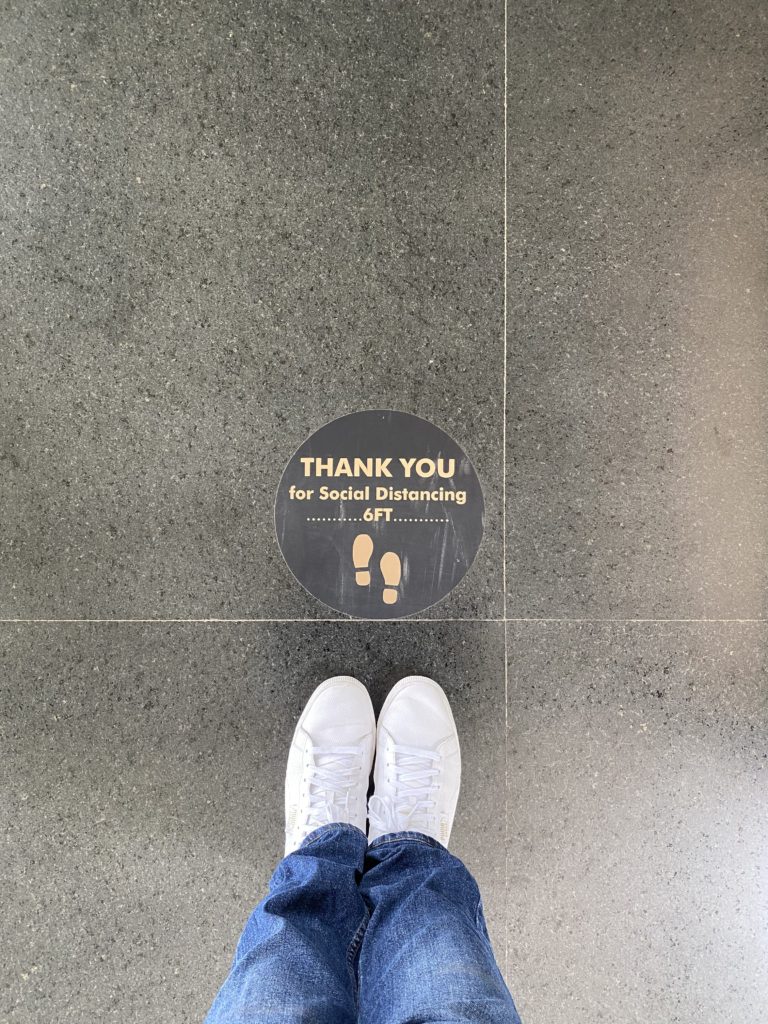 a person's feet standing on a floor with a sign