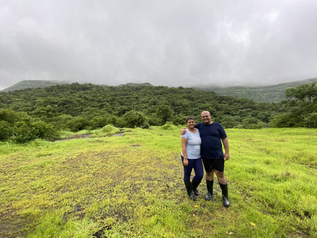 a man and woman standing in a grassy field