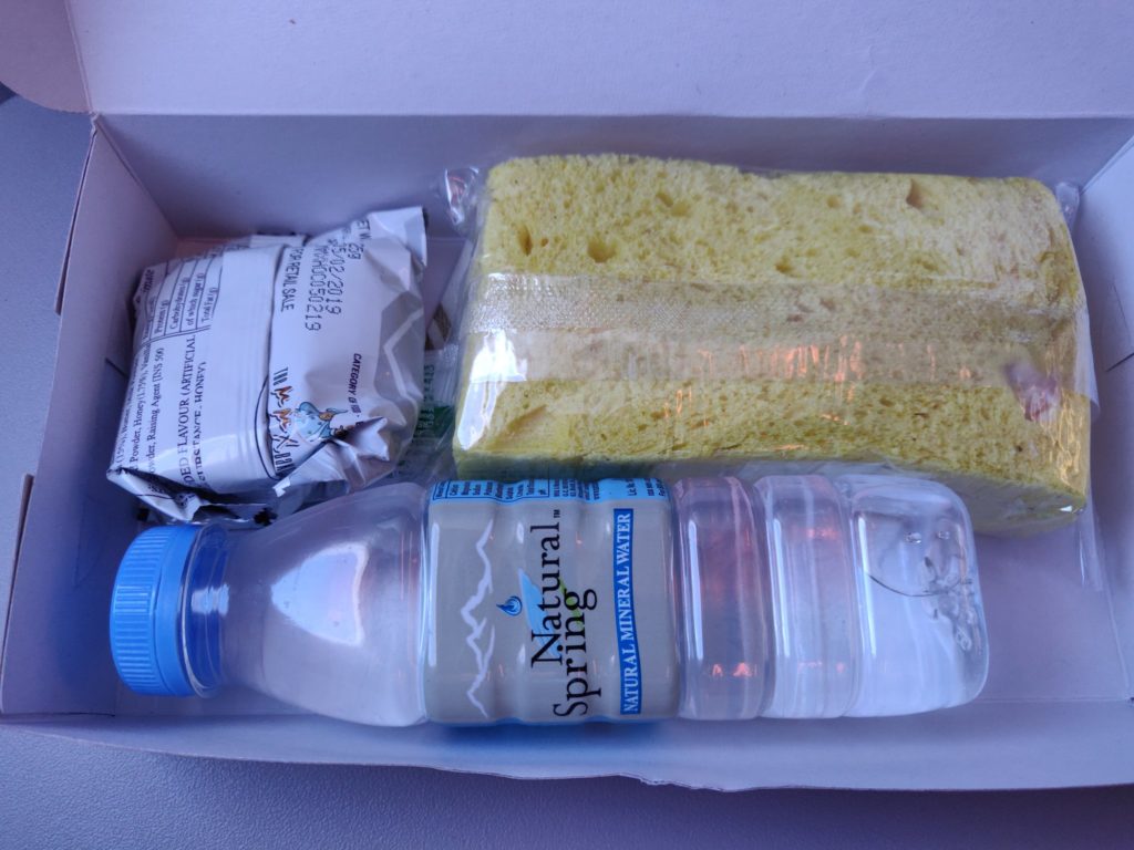 a box with a bottle of water and a sponge
