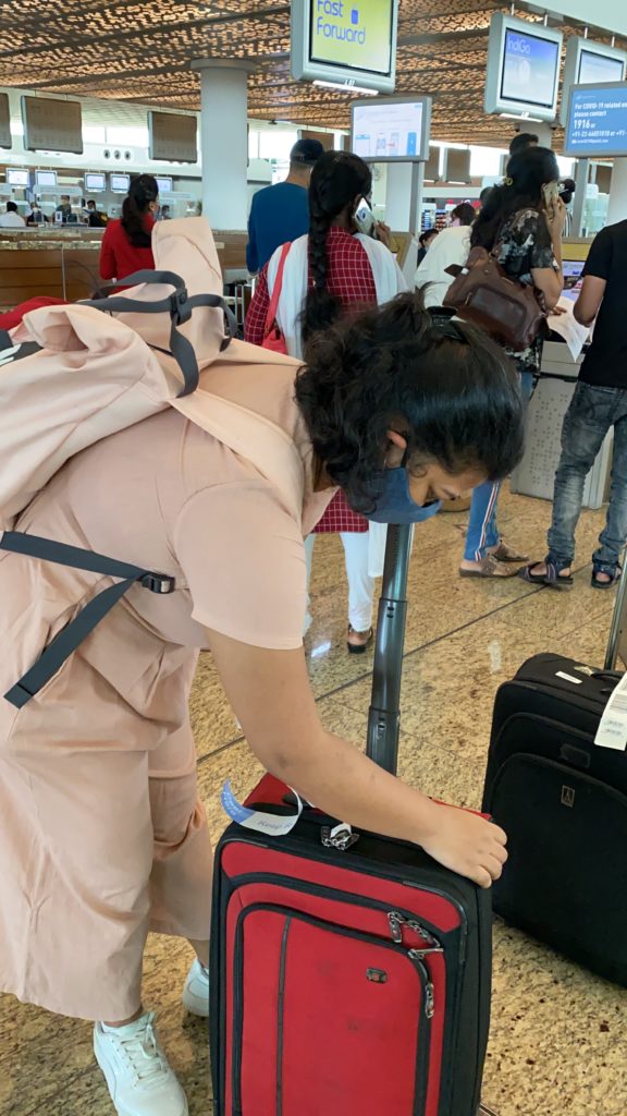 a woman wearing a face mask and holding luggage