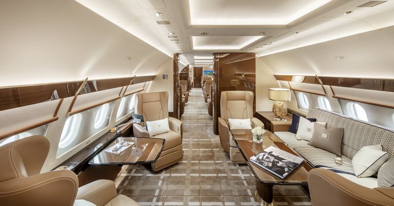 inside a luxury airplane with a few chairs and tables