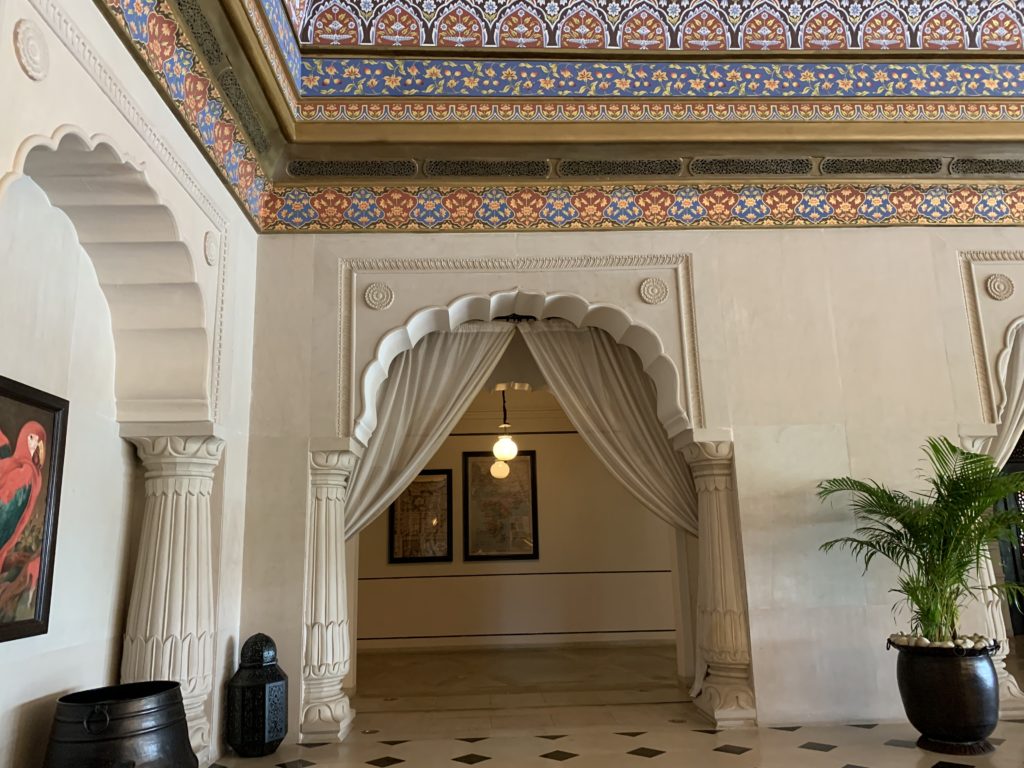 a white archway with white curtains and a tiled floor