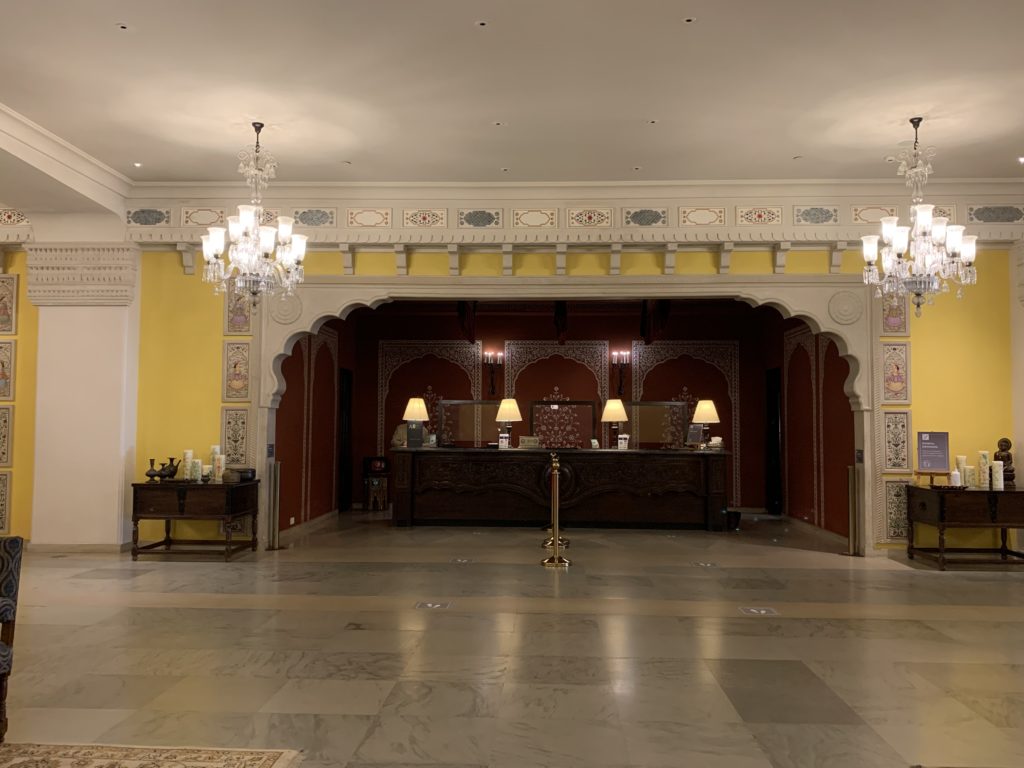 a room with a reception desk and chandeliers