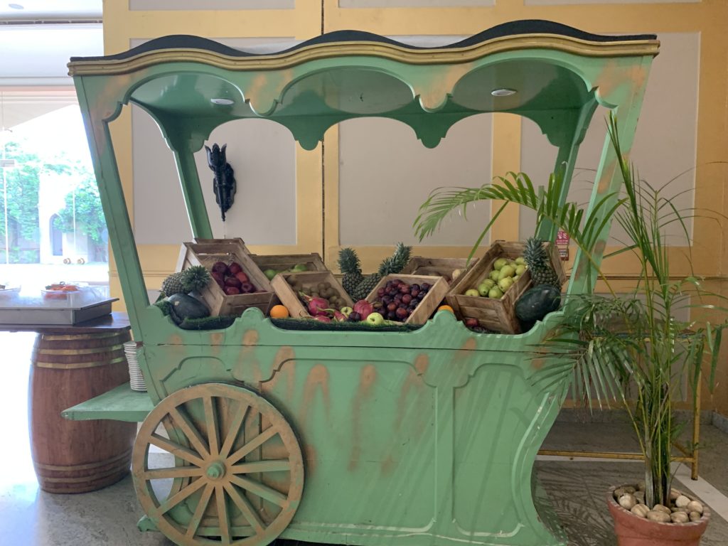 a green cart with fruit in it