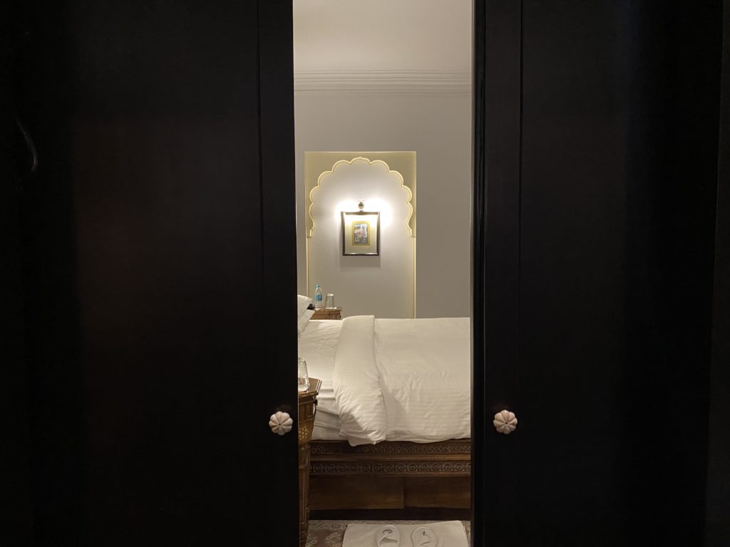 a door with a bed and a mirror