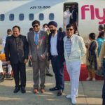 a group of men standing in front of an airplane