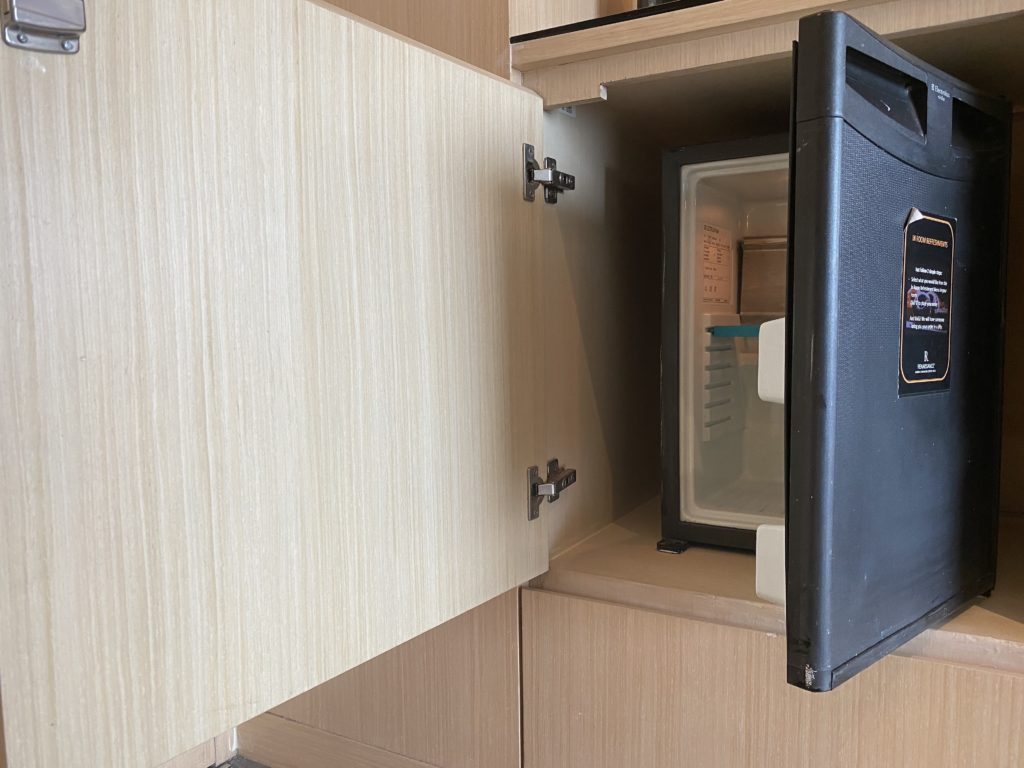 a small black refrigerator inside a cabinet