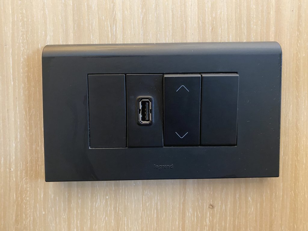 a black rectangular wall switch with buttons and a usb port