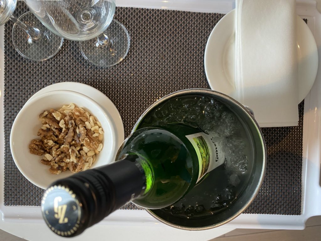 a bottle of wine in a bucket with ice and nuts