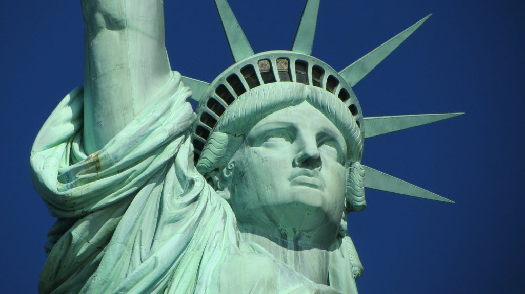 a close-up of a statue with Statue of Liberty in the background
