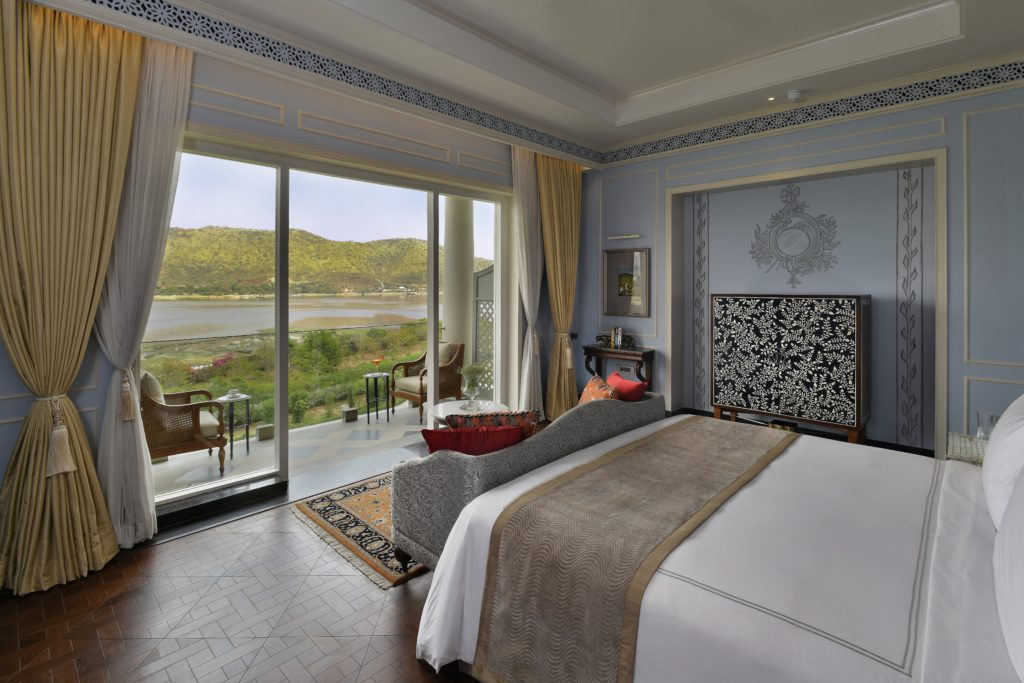 a bedroom with a view of a lake and mountains