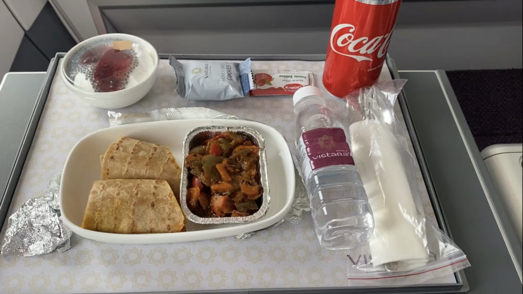 food on a tray with a drink and a bottle of water