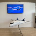 a model airplane on a stand in front of a television
