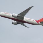 a white and red airplane flying in the sky