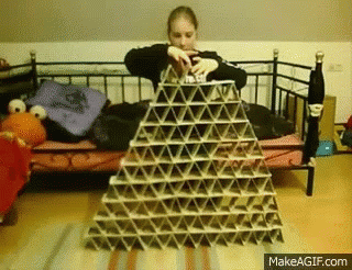 a woman building a pyramid made of cardboard