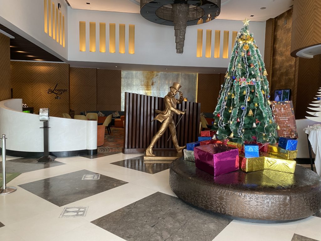 a christmas tree with presents in front of a decorated tree