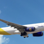 a white and yellow airplane flying in the sky