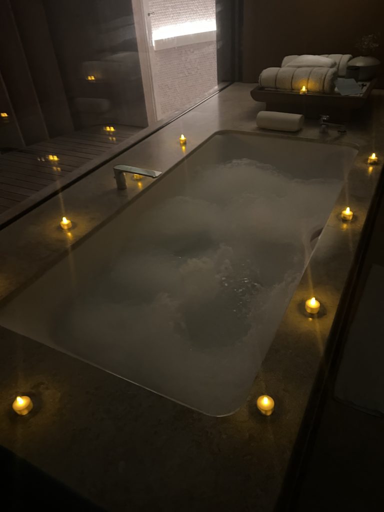 a bathtub with candles on the floor