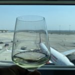 a glass of wine in front of an airplane