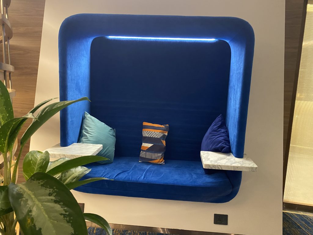 a blue couch with pillows on the wall