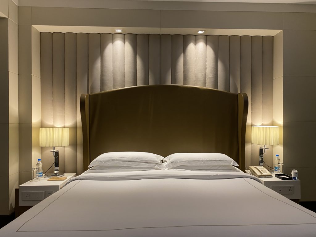 a bed with a headboard and lamps