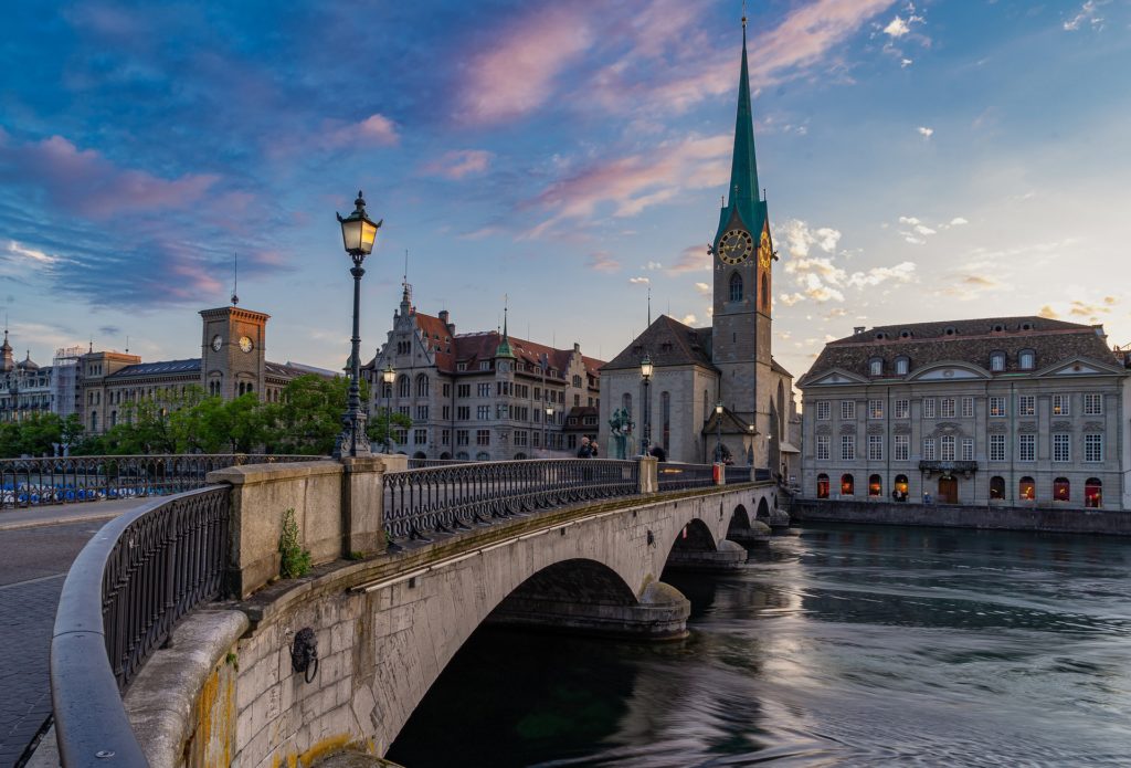 a bridge over a river with buildings and a clock tower