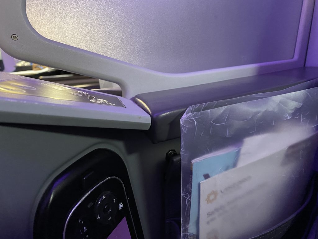 a plastic bag with a phone and a screen on the side of a plane