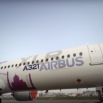 a large white airplane with purple writing on it