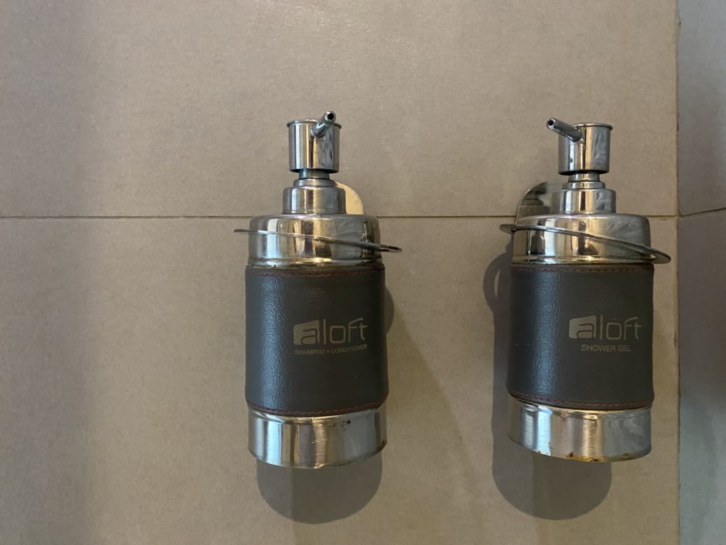 a couple of soap dispensers on a tile wall