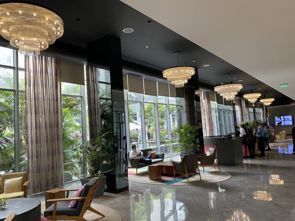 a lobby with a large chandelier and chairs