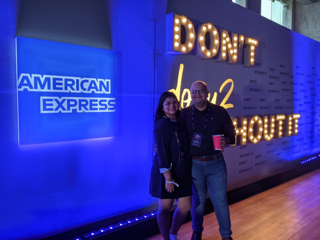 a man and woman standing in front of a sign